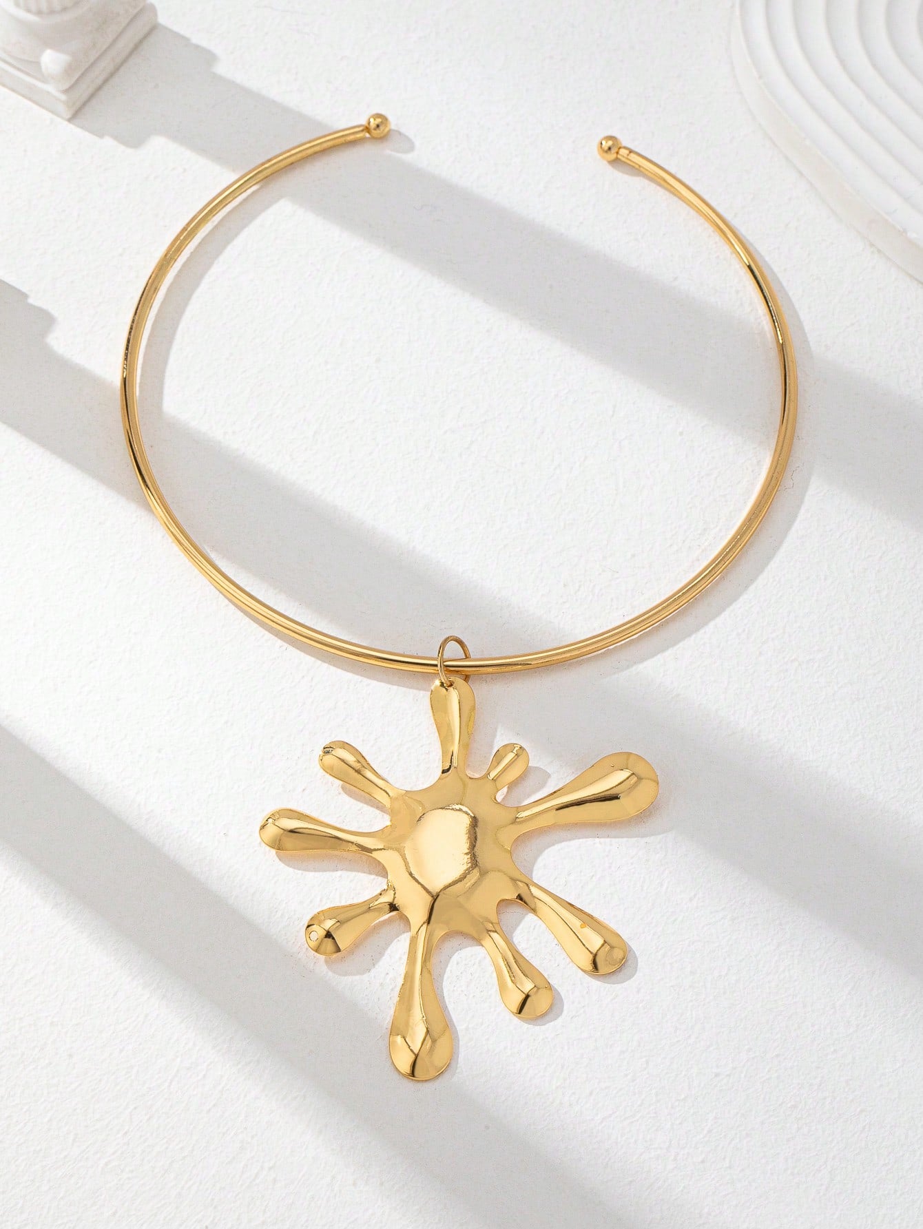 Collier ras-du-cou doré avec pendentif fleur surdimensionné